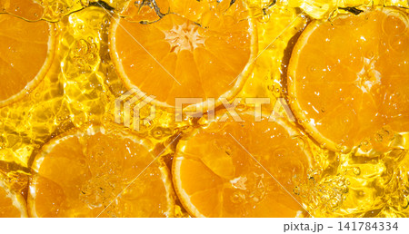 Top view of fresh orange slices submerged in clear rippling water Top view of fresh orange slices submerged in clear rippling water 141784334