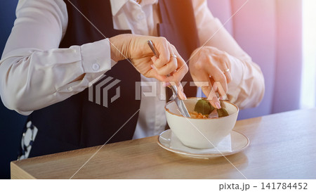 Mature Businesswoman Stirring Soup In Cafe, Steaming Broth And Spoon Motion, Warm Natural Light On Blazer Sleeves, Mindful Slow Pace, Comforting Aroma, Quiet Midday Pause From Work, Attentive Hands Mature Businesswoman Stirring Soup In Cafe, Steaming Broth And Spoon Motion, Warm Natural Light On Blazer Sleeves, Mindful Slow Pace, Comforting Aroma, Quiet Midday Pause From Work, Attentive Hands 141784452