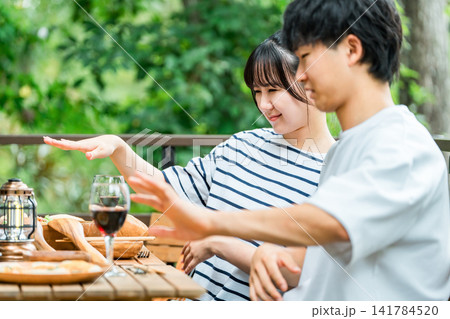 アウトドアで食事中に虫刺されで困っているカップル アウトドアで食事中に虫刺されで困っているカップル 141784520