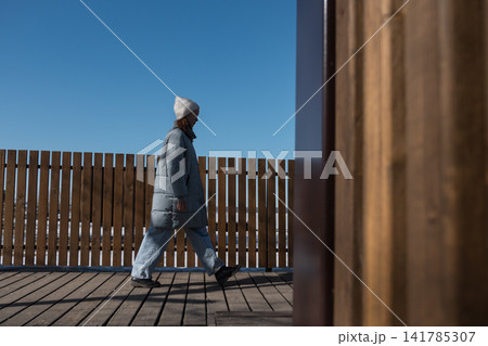 Woman walking on wooden observation deck in winter Woman walking on wooden observation deck in winter 141785307