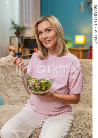 Pregnant woman eating fresh cabbage tomato salad showing healthy vitamin nutrition during pregnancy Pregnant woman eating fresh cabbage tomato salad showing healthy vitamin nutrition during pregnancy 141785798