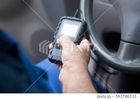 Man using car diagnostic scan tool 141786715