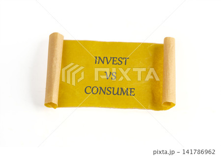 A yellow scroll with rolled ends shows the words invest versus consume. The scroll is laid flat against a white background. This visual prompts thought on financial choices 141786962