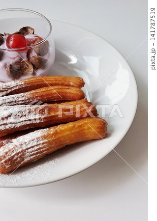 Churros, crispy and golden, dusted with sugar and cinnamon. A delicious, sweet treat often enjoyed with chocolate dipping sauce, perfect for satisfying any dessert craving. Churros, crispy and golden, dusted with sugar and cinnamon. A delicious, sweet treat often enjoyed with chocolate dipping sauce, perfect for satisfying any dessert craving. 141787519