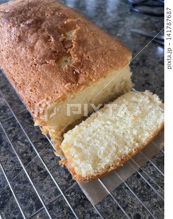 Golden brown sponge cake with a soft, airy crumb. Perfectly sliced on a rustic plate, ideal for dessert or tea time storytelling. 141787687
