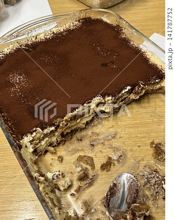 A delicious tiramisu featuring layers of espresso-soaked ladyfingers and creamy mascarpone, topped with a dusting of cocoa powder. Ideal for dessert photography, capturing classic Italian indulgence. A delicious tiramisu featuring layers of espresso-soaked ladyfingers and creamy mascarpone, topped with a dusting of cocoa powder. Ideal for dessert photography, capturing classic Italian indulgence. 141787752