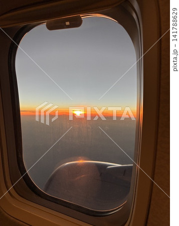 飛行機の窓から望む夕日と雲海の空の旅 飛行機の窓から望む夕日と雲海の空の旅 141788629