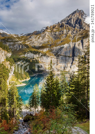 Oeschinensee Kandersteg Swiss Alps Switzerland turquoise mountain lake surrounded by pine forest and steep rocky cliffs Oeschinensee Kandersteg Swiss Alps Switzerland turquoise mountain lake surrounded by pine forest and steep rocky cliffs 141789021