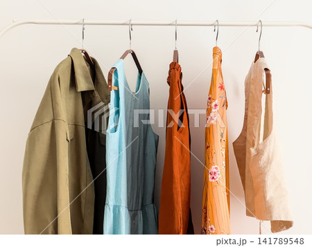 White Metal Rack with Summer Outfits and Linen Vest, Angled View White Metal Rack with Summer Outfits and Linen Vest, Angled View 141789548
