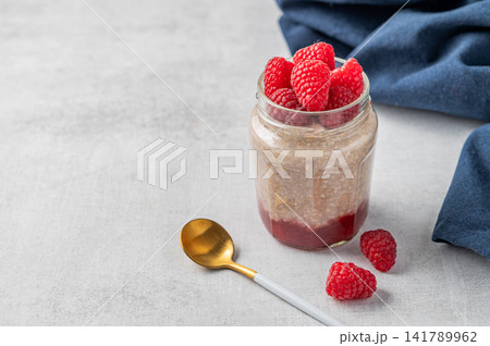 Oatmeal in a jar with raspberries overnight in alternative milk on a light background Oatmeal in a jar with raspberries overnight in alternative milk on a light background 141789962