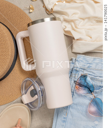 Blank ivory 40oz tumbler mockup, stainless steel travel thermos on denim and dark red sweatshirt Blank ivory 40oz tumbler mockup, stainless steel travel thermos on denim and dark red sweatshirt 141790025