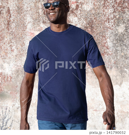Blank dark blue t-shirt mockup on smiling black man outdoors, front view with copy space Blank dark blue t-shirt mockup on smiling black man outdoors, front view with copy space 141790032