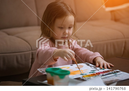 Little girl painting with watercolors expressing creativity Little girl painting with watercolors expressing creativity 141790768