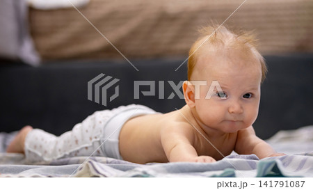 Baby exploring world during tummy time activity 141791087