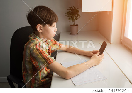 Young student distracting by smartphone instead of studying homework Young student distracting by smartphone instead of studying homework 141791264