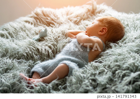 Sleeping newborn baby resting on soft fuzzy blanket Sleeping newborn baby resting on soft fuzzy blanket 141791343