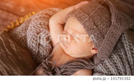 Newborn baby boy sleeping peacefully in knit hat Newborn baby boy sleeping peacefully in knit hat 141791382