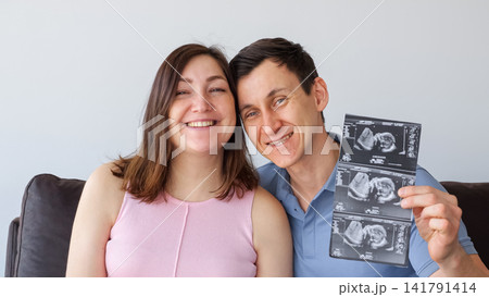 Expecting celebrating new pregnancy with sonogram 141791414