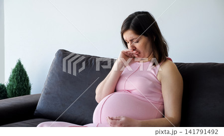 Pregnant woman experiencing morning sickness and nausea discomfort 141791492