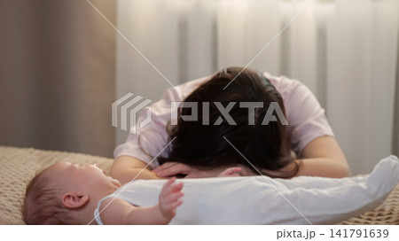 Stressed mother dealing with a fussy crying newborn baby Stressed mother dealing with a fussy crying newborn baby 141791639