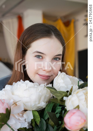 Young woman smiling with a beautiful bouquet of peonies Young woman smiling with a beautiful bouquet of peonies 141791668