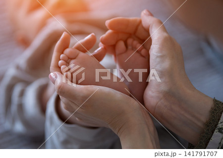 Mother holding baby feet showing and care Mother holding baby feet showing and care 141791707