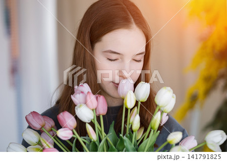 Young girl smelling fresh pink and white tulips Young girl smelling fresh pink and white tulips 141791825
