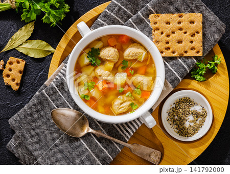 Old fashioned poultry meatball soup in clear broth Old fashioned poultry meatball soup in clear broth 141792000