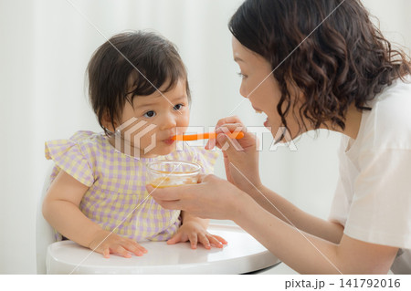 離乳食を食べる1歳の女の子 離乳食を食べる1歳の女の子 141792016