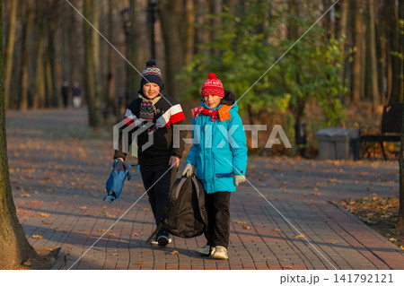 School children walk together along the path in the park on an autumn day, School children walk together along the path in the park on an autumn day, 141792121
