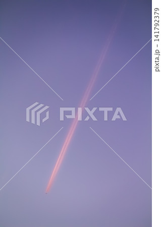 Airplane forming contrail in pink sunset sky Airplane forming contrail in pink sunset sky 141792379