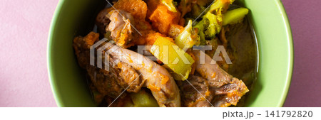 A bowl contains stewed quail mixed with fresh vegetables such as carrots, broccoli, and zucchini. This meal is prepared for breakfast or lunch and offers protein and nutrition, banner 141792820