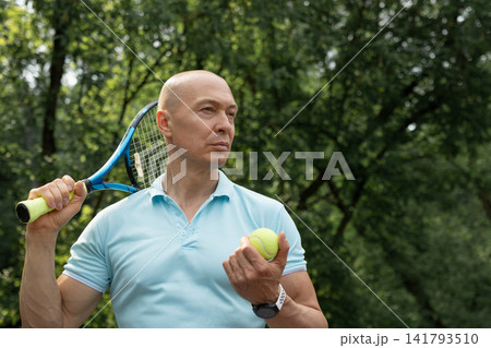 Confident tennis player holding racket and ball before match Confident tennis player holding racket and ball before match 141793510