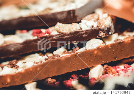 Artisan handmade chocolate bars with nuts and dried fruits close-up Artisan handmade chocolate bars with nuts and dried fruits close-up 141793942