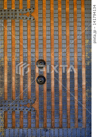 Ancient Wooden Door with Iron Studs Rivets and Ornate Metal Handles Close Up Ancient Wooden Door with Iron Studs Rivets and Ornate Metal Handles Close Up 141794134
