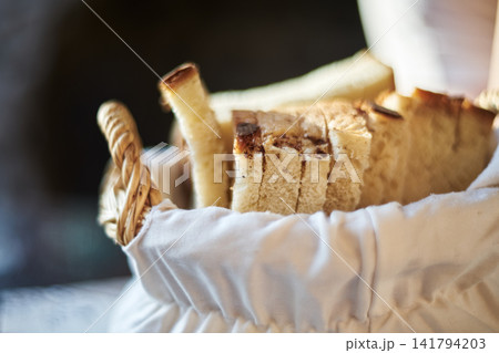 Close-up of freshly sliced white bread arranged neatly inside a woven basket with cloth Close-up of freshly sliced white bread arranged neatly inside a woven basket with cloth 141794203
