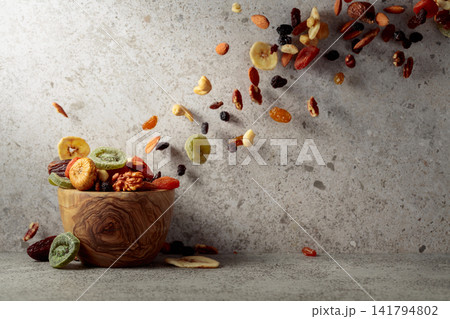 Mix of dried fruits and nuts on a gray stone table. Mix of dried fruits and nuts on a gray stone table. 141794802