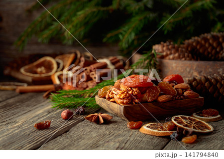 Dried fruits and nuts on an old wooden table. Dried fruits and nuts on an old wooden table. 141794840