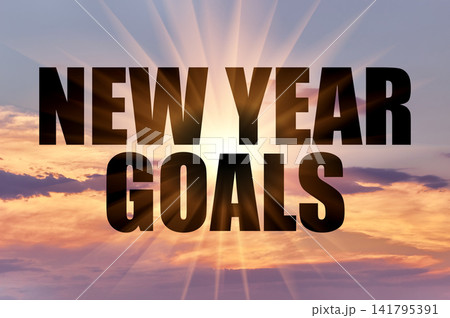 New year goals conceptual phrase on a dramatic colorful evening sky with rays New year goals conceptual phrase on a dramatic colorful evening sky with rays 141795391