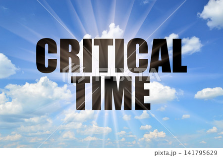 Critical time text against bright sun rays in blue sky Critical time text against bright sun rays in blue sky 141795629