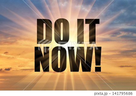 Do it now text against bright sun rays in morning sky Do it now text against bright sun rays in morning sky 141795686