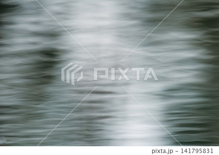 Abstract background resembling brushed metal steel or luxury satin silk fabric. Soft fluid texture with silver reflections and horizontal lines. Artistic long exposure ripples water surface background Abstract background resembling brushed metal steel or luxury satin silk fabric. Soft fluid texture with silver reflections and horizontal lines. Artistic long exposure ripples water surface background 141795831