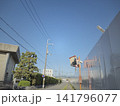 青空に映えるオレンジ色のカーブミラーと建設機械 141796077