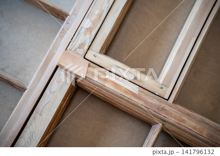 Antique window frame at worktable in restoration workshop undergoing renovation and reconstruction. Antique window frame at worktable in restoration workshop undergoing renovation and reconstruction. 141796132
