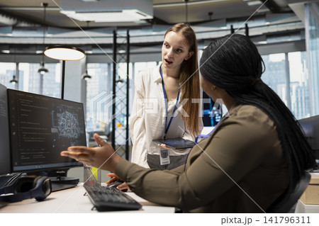 Manager guiding junior dev on how to do tasks with machine learning during AI project development. Team leader mentoring young woman on neural network implementation during internship Manager guiding junior dev on how to do tasks with machine learning during AI project development. Team leader mentoring young woman on neural network implementation during internship 141796311