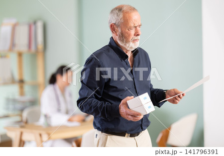 Elderly male patient with prescription and medicine box Elderly male patient with prescription and medicine box 141796391
