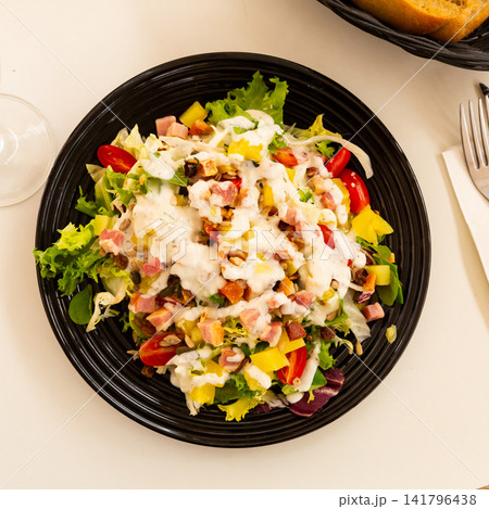 spanish lettuce salad with sauce and bacon in black plate for dinner spanish lettuce salad with sauce and bacon in black plate for dinner 141796438