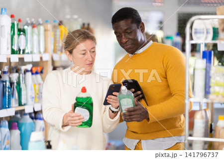 Couple man and woman scanning qr code for dishwashing detergent Couple man and woman scanning qr code for dishwashing detergent 141796737