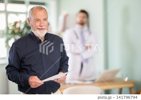 Elderly male patient leaving medical office with test results Elderly male patient leaving medical office with test results 141796794
