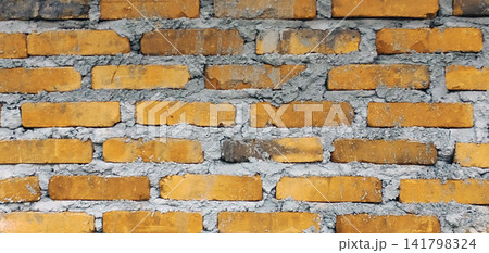 Yellow brick wall texture with rough cement mortar. Yellow brick wall texture with rough cement mortar. 141798324